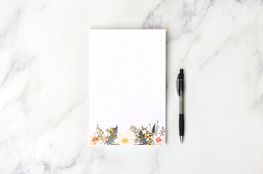 White - dotted notepad with colourful florals on the bottom of the nnotepad
