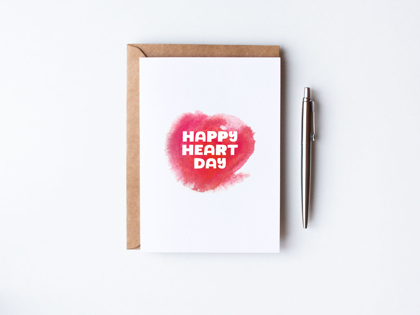 White Valentines Day card saying Happy Heart Day in Pink and White